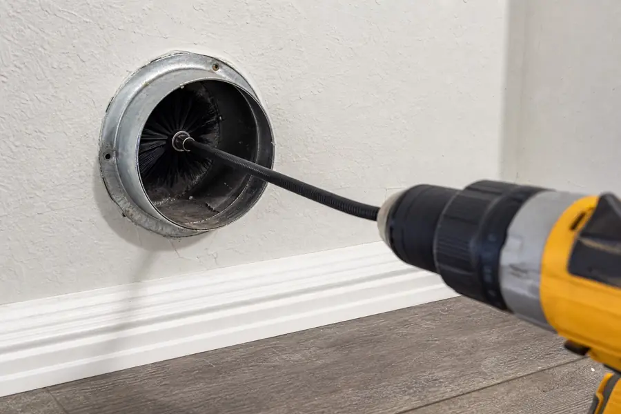 AirFresh technician using a rotary brush and vacuum to clean a dryer vent duct