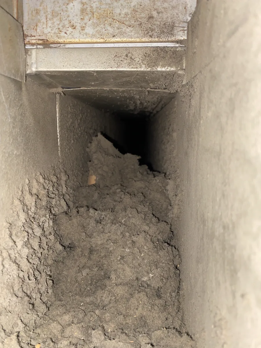 Before: Air duct packed with heavy dust and debris