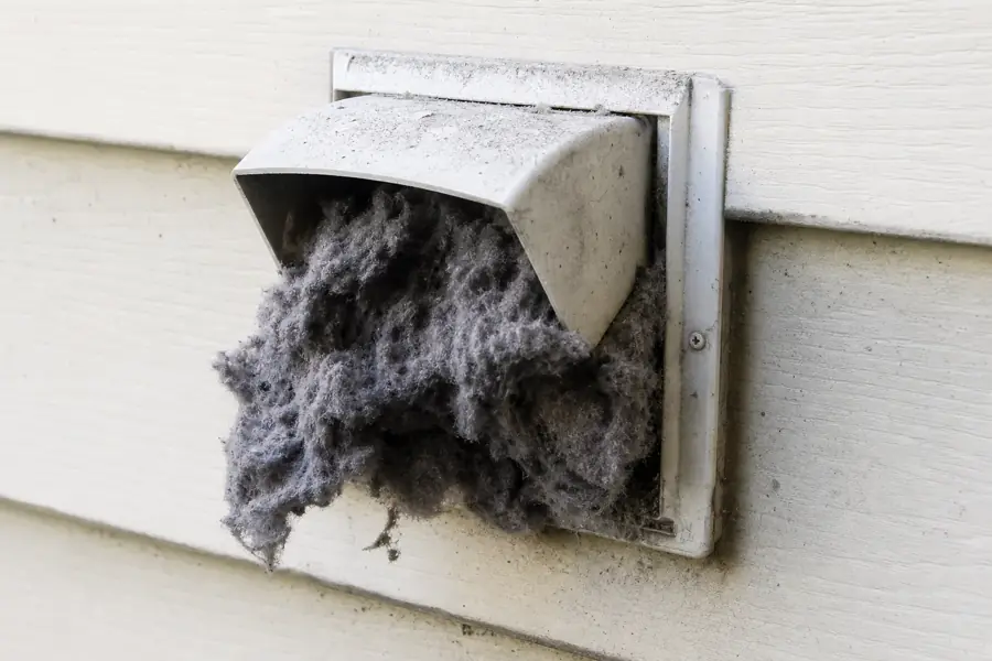 Before: Exterior dryer vent hood clogged with lint