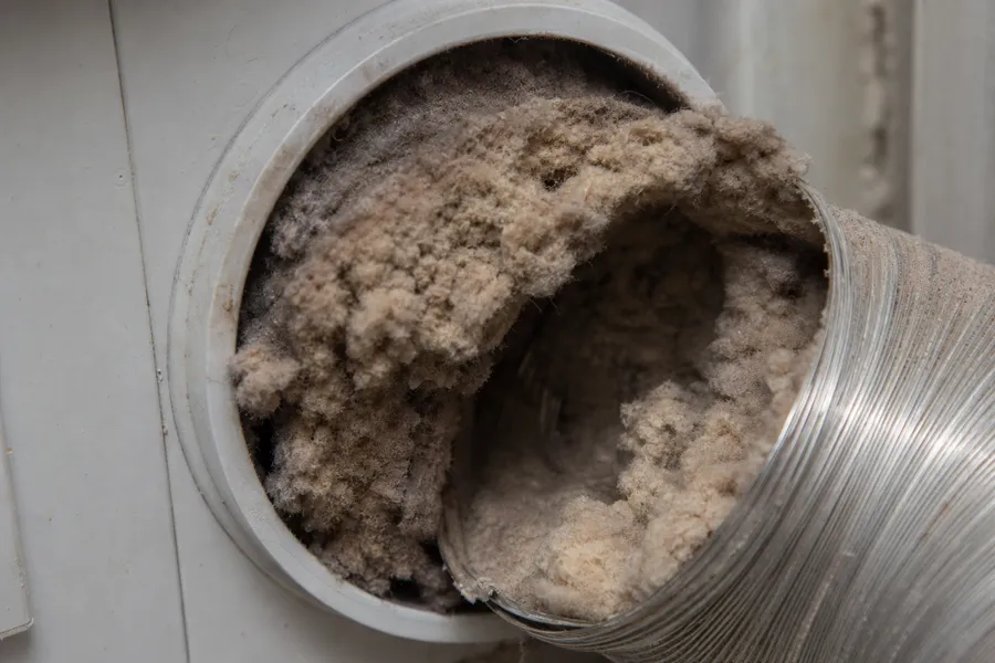 Dryer vent transition hose packed with lint where it connects to the wall