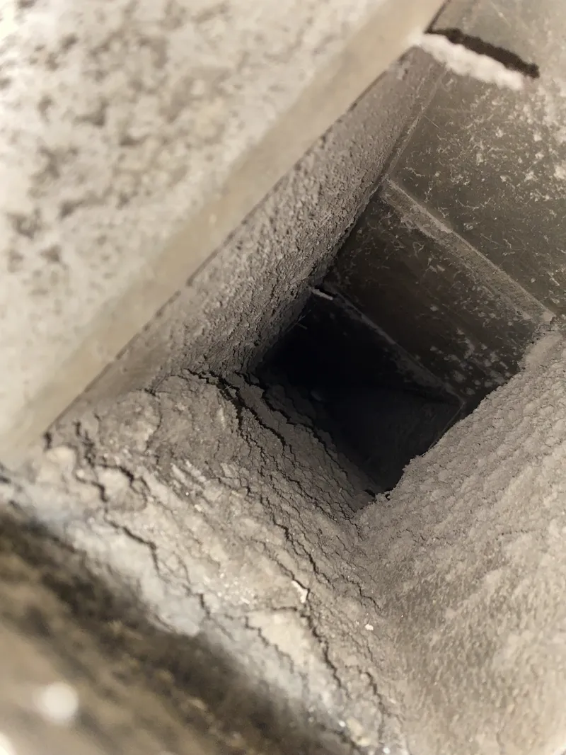 Before: Air duct interior caked with heavy dust and debris