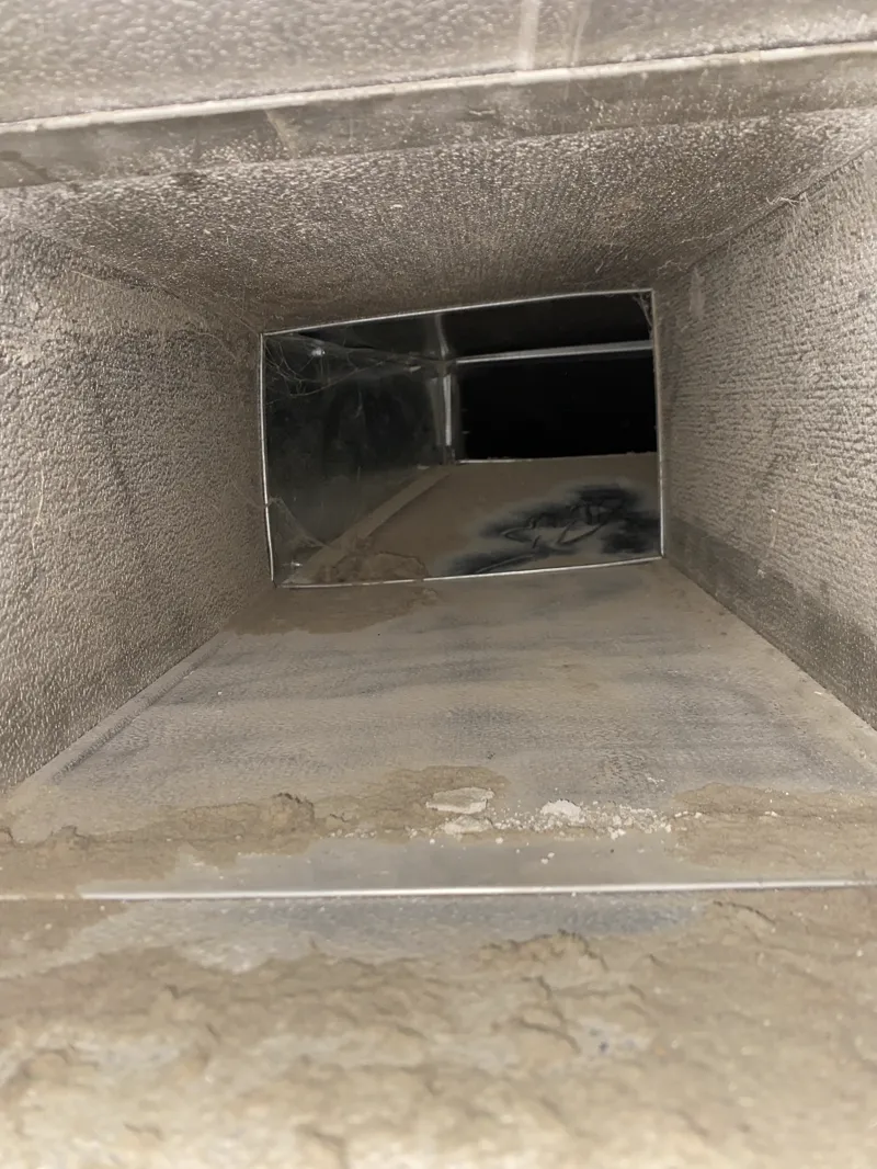 Before: Dust-coated ductwork before cleaning